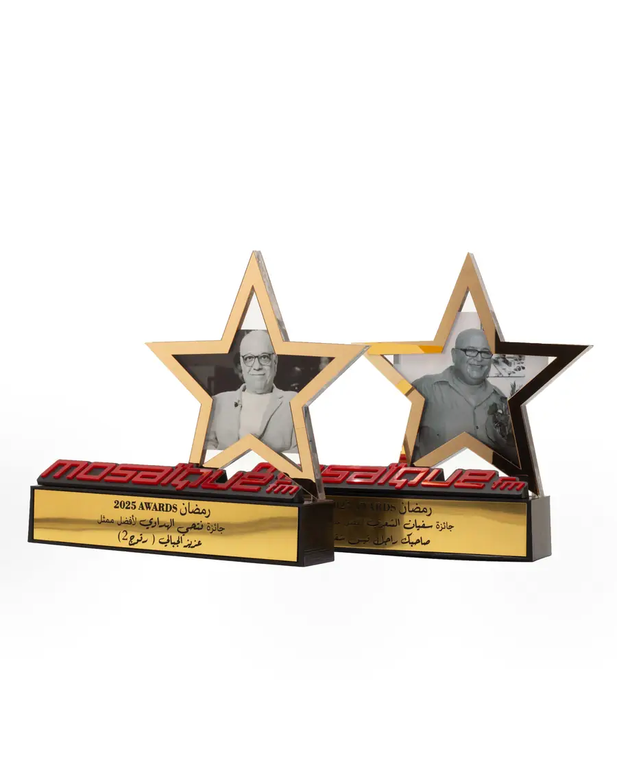 Deux étoiles noires et dorées aux portraits gravés, sur socles rouges gravés en arabe